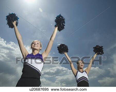 Two cheerleaders holding pom poms over head View Large Photo Image Stock Photography - Two cheerleaders holding pom poms over head. Fotosearch