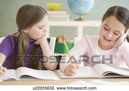 Two girls studying in classroom View Large Photo Image Stock Image - Two girls studying in classroom. Fotosearch
