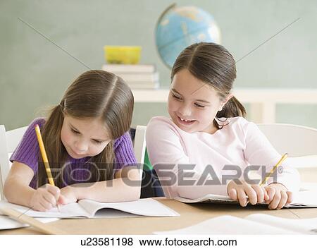 Two girls studying in classroom View Large Photo Image Stock Photo - Two girls studying in classroom. Fotosearch
