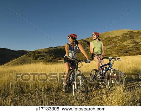 Stock Photography - Two women on mountain bikes, Salt Flats, Utah, United States. Fotosearch
