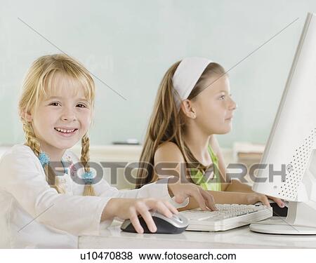 Two young girls using computers View Large Photo Image Stock Photo - Two young girls using computers. Fotosearch