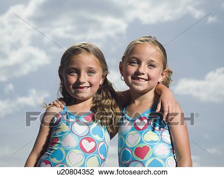 Two young sisters hugging View Large Photo Image Stock Image - Two young sisters hugging. Fotosearch