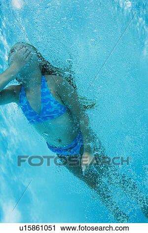 Stock Image - Underwater shot of girl swimming, Florida, United States. Fotosearch
