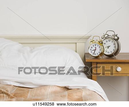 Unmade bed with alarm clocks View Large Photo Image Stock Photo - Unmade bed with alarm clocks. Fotosearch
