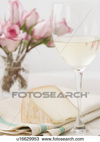 Stock Image - White wine with cheese and flowers. Fotosearch