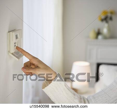 Woman adjusting digital thermostat View Large Photo Image Stock Photo - Woman adjusting digital thermostat. Fotosearch