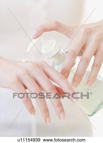 Stock Photo - Woman applying hand lotion. Fotosearch
