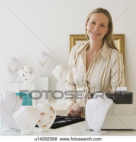 Stock Photo - Woman behind counter at jewelry store. Fotosearch