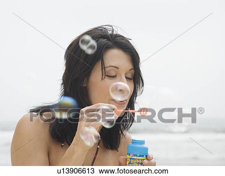 Woman blowing bubbles at beach View Large Photo Image Stock Image - Woman blowing bubbles at beach. Fotosearch