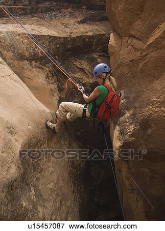 Stock Photo - Woman canyon rappelling. Fotosearch