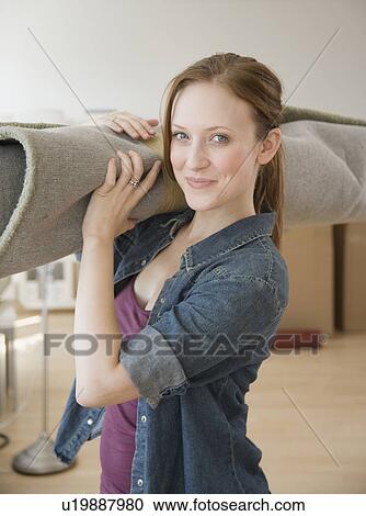 Woman carrying rug in new house View Large Photo Image Stock Image - Woman carrying rug in new house. Fotosearch
