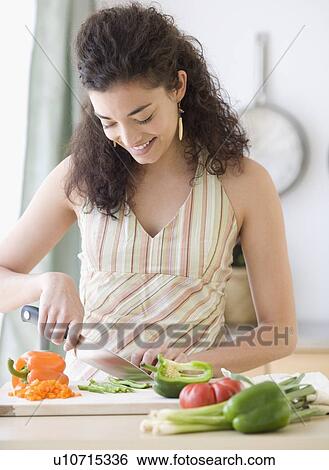 Stock Photograph - Woman chopping vegetables. Fotosearch