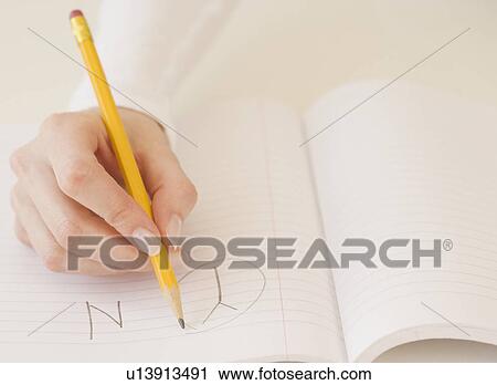 Stock Image - Woman circling the letter Y in notebook. Fotosearch