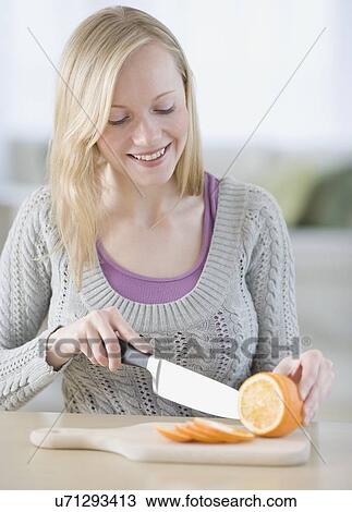 Stock Image - Woman cutting orange. Fotosearch