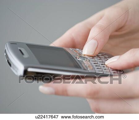 Stock Photo - Woman dialing cell phone. Fotosearch