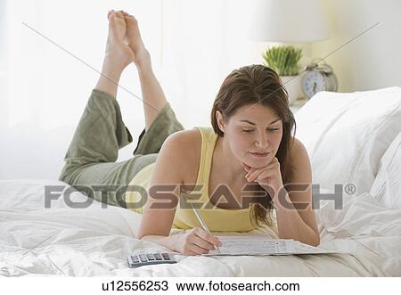 Woman doing finances on bed View Large Photo Image Stock Image - Woman doing finances on bed. Fotosearch