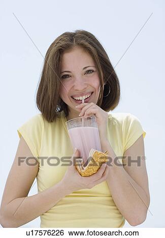 Stock Photograph - Woman drinking milkshake with straw. Fotosearch
