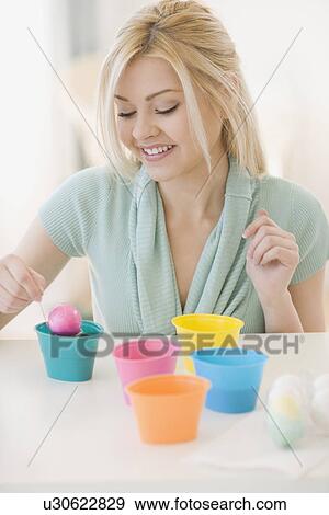 Stock Photo - Woman dying Easter eggs. Fotosearch