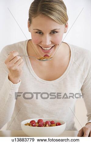 Stock Photo - Woman eating cereal. Fotosearch