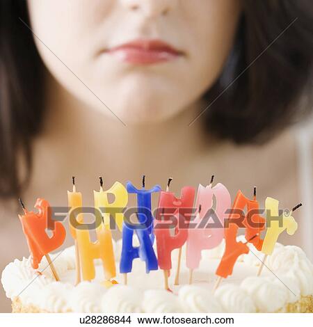 Woman frowning at blown out birthday candles View Large Photo Image Picture - Woman frowning at blown out birthday candles. Fotosearch