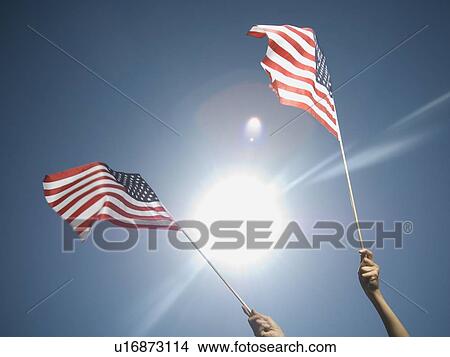 Picture - Woman holding American flags. Fotosearch
