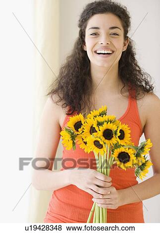 Stock Photo - Woman holding bouquet of sunflowers. Fotosearch