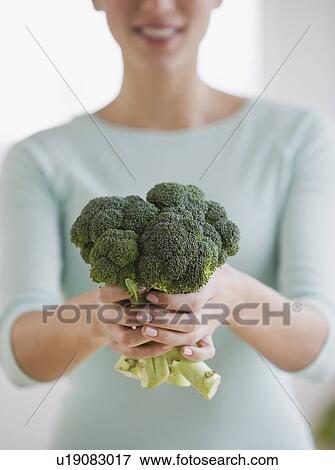 Stock Photo - Woman holding broccoli. Fotosearch