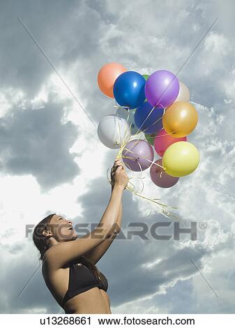 Woman holding bunch of balloons View Large Photo Image Stock Image - Woman holding bunch of balloons. Fotosearch