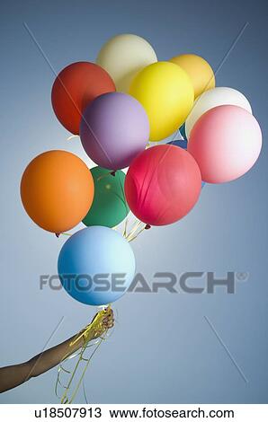 Woman holding bunch of balloons View Large Photo Image Stock Image - Woman holding bunch of balloons. Fotosearch