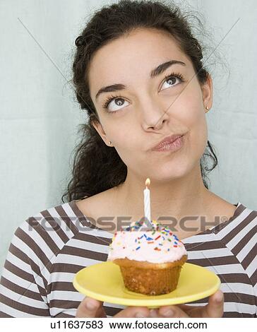 Woman holding cupcake with candle View Large Photo Image Stock Image - Woman holding cupcake with candle. Fotosearch