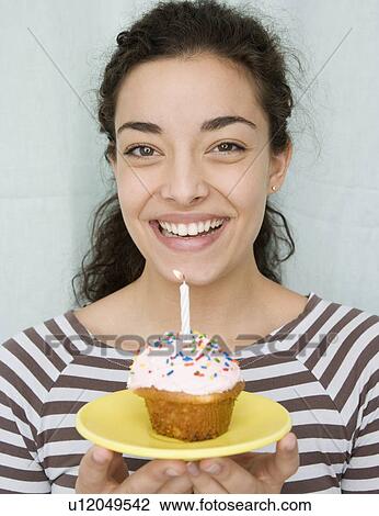 Woman holding cupcake with candle View Large Photo Image Stock Image - Woman holding cupcake with candle. Fotosearch