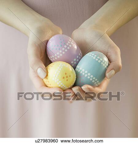 Stock Image - Woman holding decorated eggs. Fotosearch