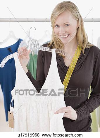 Woman holding dress in clothing store View Large Photo Image Stock Photo - Woman holding dress in clothing store. Fotosearch