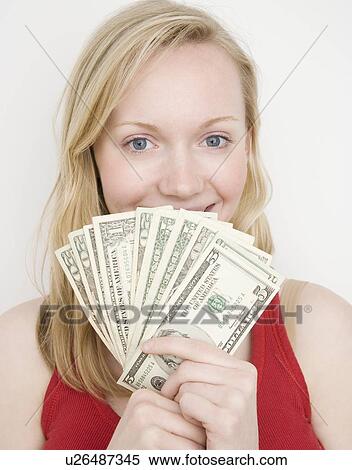 Stock Photography - Woman holding fanned out money. Fotosearch