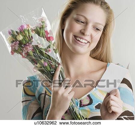 Woman holding flowers and card View Large Photo Image Stock Image - Woman holding flowers and card. Fotosearch