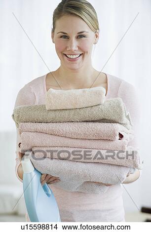Woman holding folded towels View Large Photo Image Picture - Woman holding folded towels. Fotosearch
