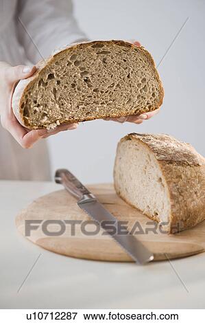 Stock Photo - Woman holding loaf of bread. Fotosearch