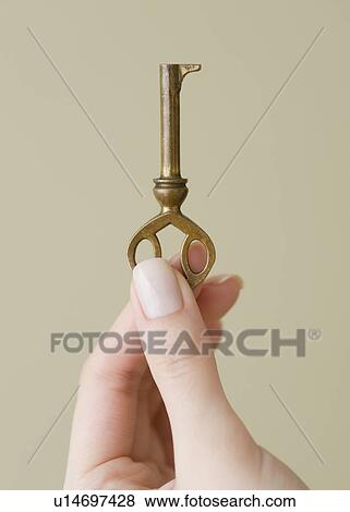 Stock Photo - Woman holding old fashioned key. Fotosearch