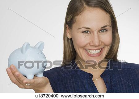 Stock Image - Woman holding piggy bank. Fotosearch