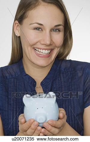 Stock Photography - Woman holding piggy bank. Fotosearch