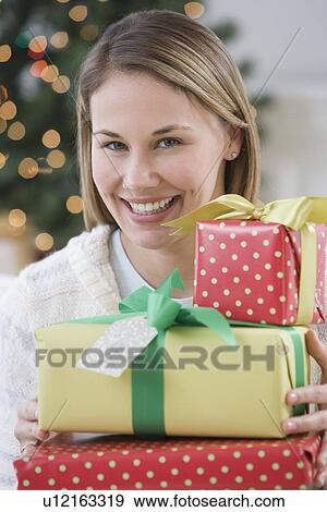 Woman holding pile of Christmas gifts View Large Photo Image Stock Photo - Woman holding pile of Christmas gifts. Fotosearch