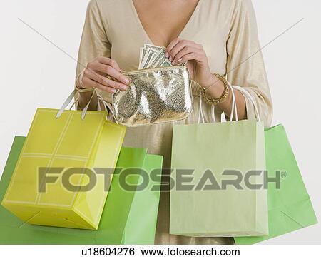 Stock Photograph - Woman holding shopping bags and purse. Fotosearch
