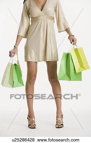 Stock Photo - Woman holding shopping bags. Fotosearch