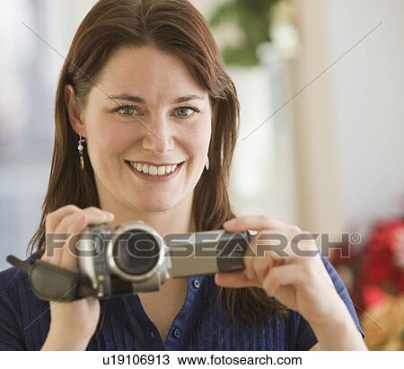 Woman holding video camera View Large Photo Image Stock Image - Woman holding video camera. Fotosearch