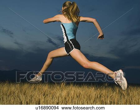 Woman in athletic gear jumping View Large Photo Image Picture - Woman in athletic gear jumping. Fotosearch