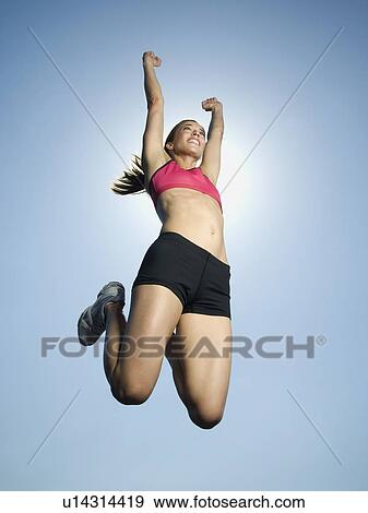 Stock Photo - Woman in athletic gear jumping. Fotosearch