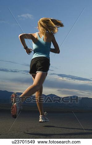 Stock Photo - Woman in athletic gear running. Fotosearch