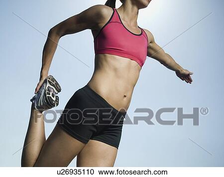 Woman in athletic gear stretching View Large Photo Image Stock Image - Woman in athletic gear stretching. Fotosearch