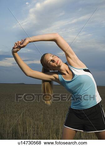 Stock Photo - Woman in athletic gear stretching. Fotosearch
