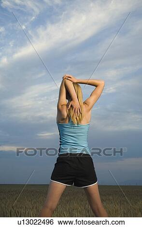 Woman in athletic gear stretching View Large Photo Image Stock Photograph - Woman in athletic gear stretching. Fotosearch
